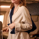Cozy cream travel jacket with navy accents, perfect for flights, made from soft, comfortable material.