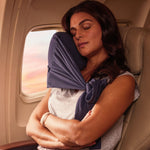 Comfortable navy blue travel neck pillow providing support for restful sleep on a plane.
