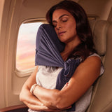 Comfortable navy blue travel neck pillow providing support for restful sleep on a plane.