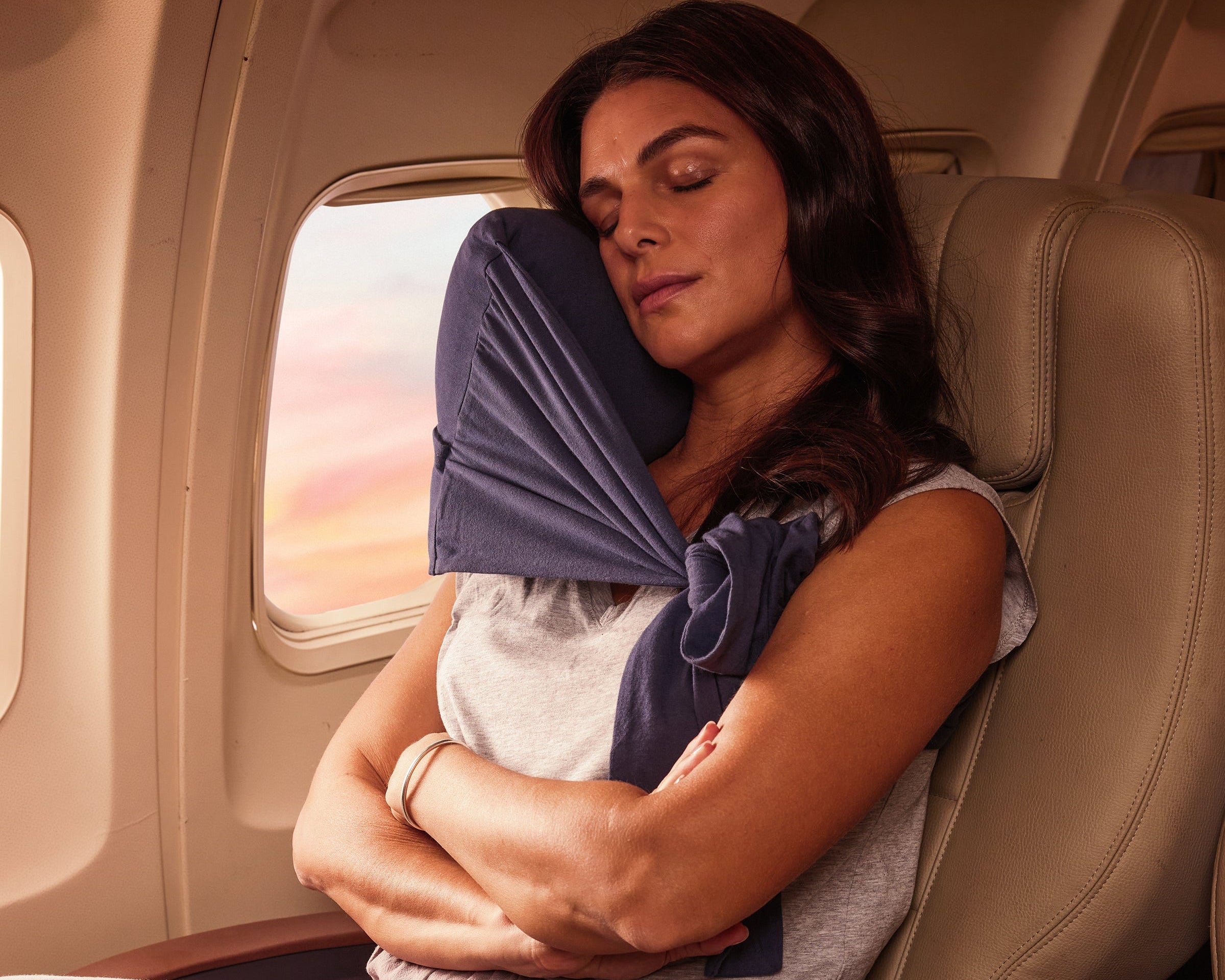 Comfortable navy blue travel neck pillow providing support for restful sleep on a plane.