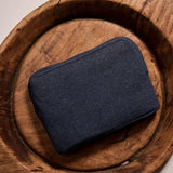 Navy blue fabric pouch on a wooden tray, perfect for organizing accessories or cosmetics.
